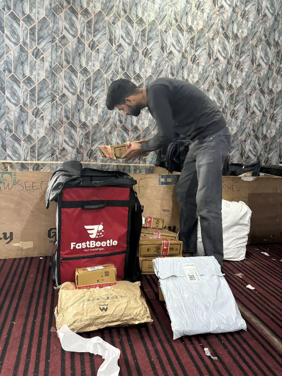 A delivery boy double-checks the parcels to ensure they are meant for the residents of the area where he is assigned to deliver.